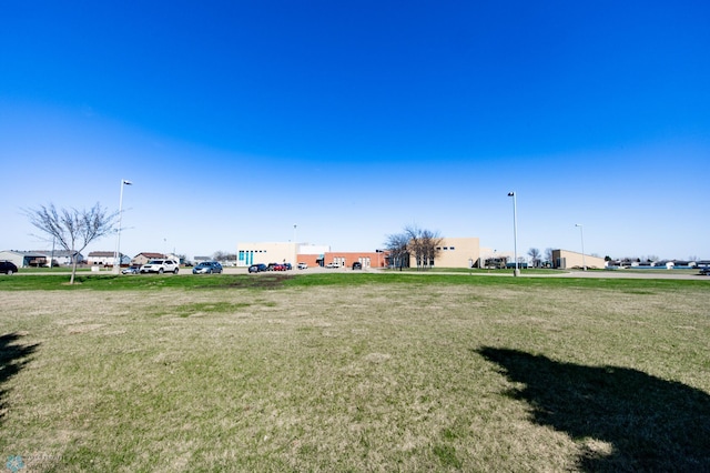 view of community with a yard and uncovered parking