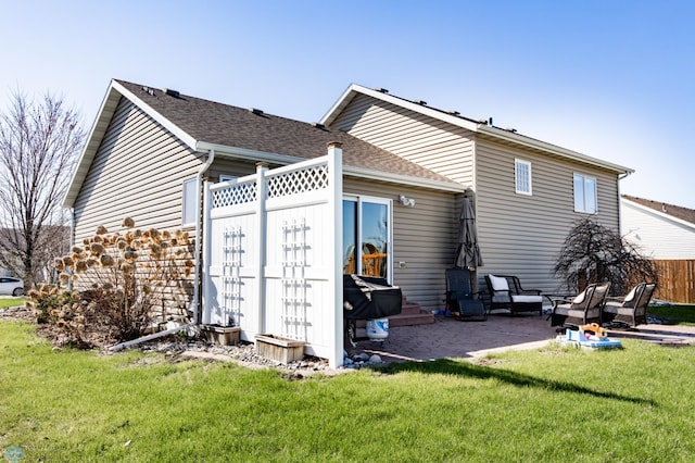 back of house featuring a lawn, fence, a patio area, and roof with shingles