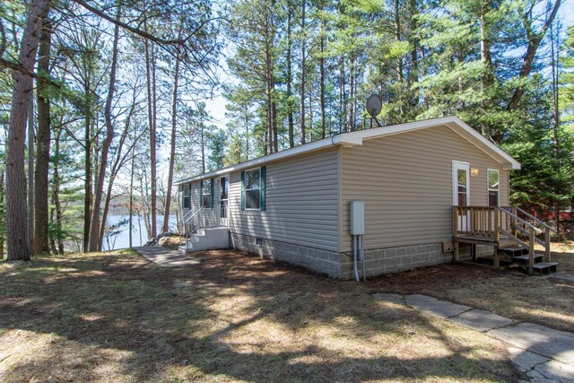 view of property exterior featuring a water view and crawl space