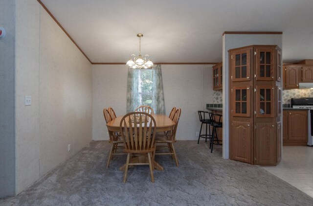 dining space featuring crown molding, a chandelier, and light colored carpet
