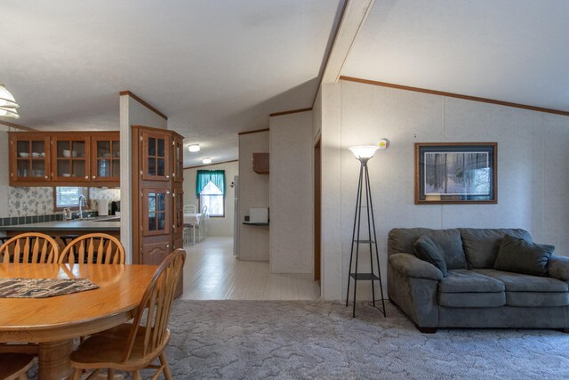 dining room featuring lofted ceiling and light carpet