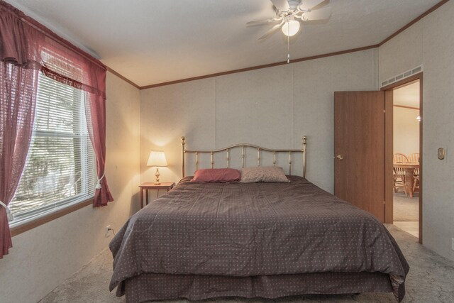 carpeted bedroom with ceiling fan, vaulted ceiling, ornamental molding, and multiple windows