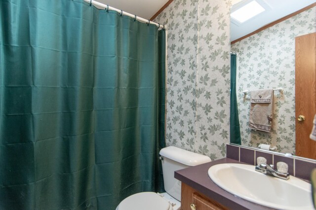 bathroom featuring crown molding, toilet, and wallpapered walls