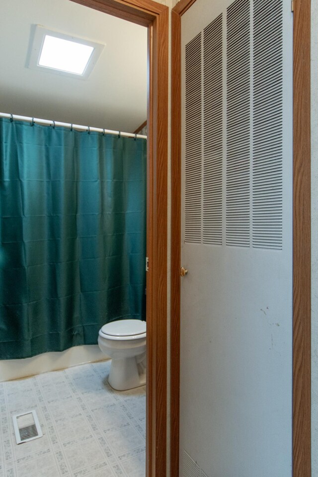 bathroom with toilet, a heating unit, visible vents, and curtained shower