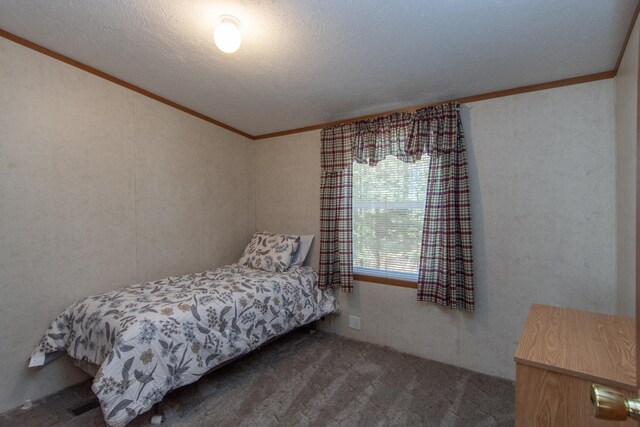 bedroom with crown molding, a textured ceiling, and carpet floors