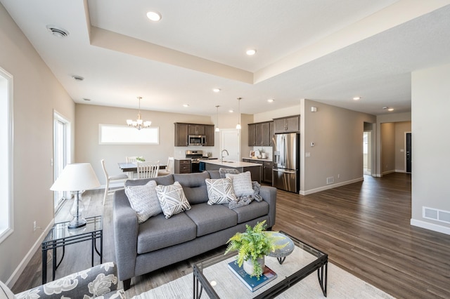living area with visible vents, baseboards, dark wood-style floors, a notable chandelier, and recessed lighting