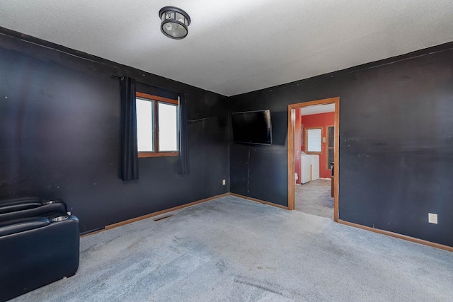 carpeted spare room with a textured ceiling, baseboards, and visible vents