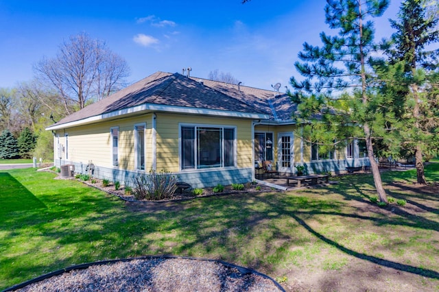 rear view of property with a lawn, a patio, and a shingled roof