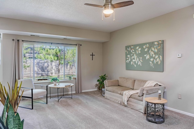 carpeted living room featuring ceiling fan and baseboards