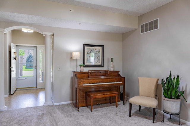 living area with decorative columns, arched walkways, carpet floors, and baseboards