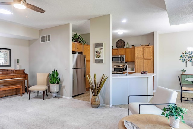 living area with light colored carpet, a ceiling fan, and baseboards