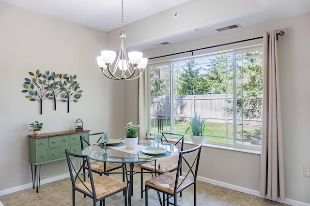 dining room featuring a chandelier, healthy amount of natural light, and baseboards
