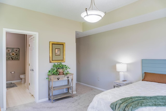 bedroom featuring light carpet, baseboards, and connected bathroom