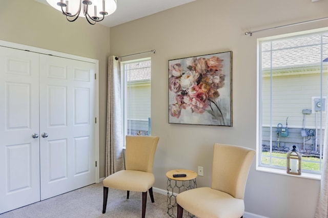 sitting room featuring carpet floors, plenty of natural light, a chandelier, and baseboards