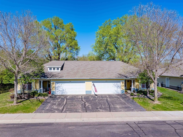 view of front of property featuring an attached garage, asphalt driveway, and a front lawn