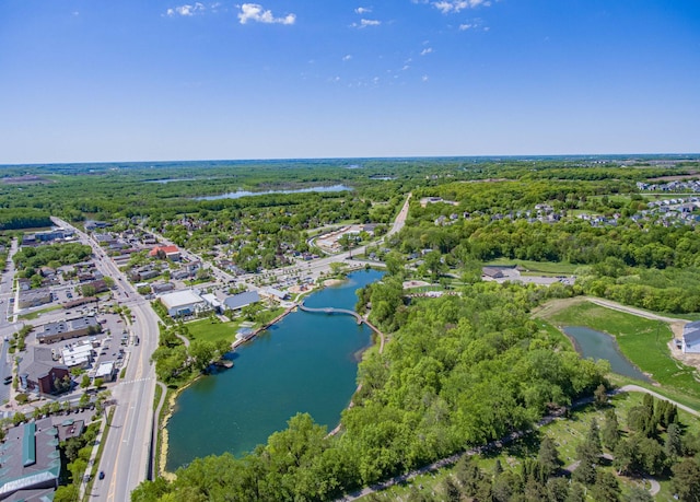 view of property location with a nearby body of water and a forest