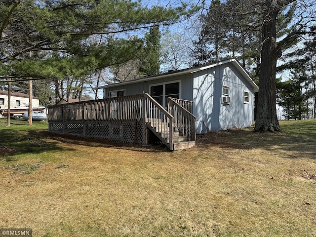 rear view of property with a lawn and a wooden deck