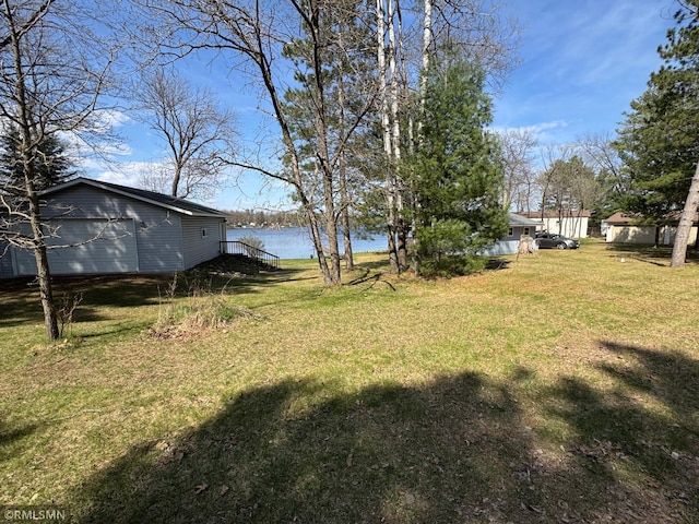 view of yard featuring a detached garage and a water view
