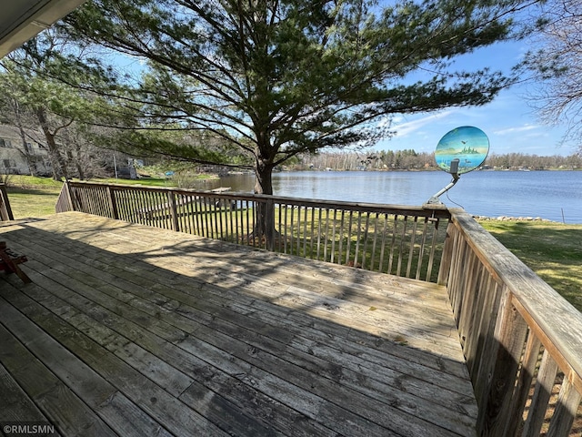 wooden deck with a yard and a water view