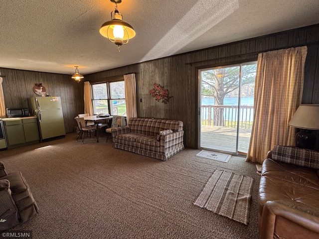 carpeted living room featuring wooden walls and a textured ceiling