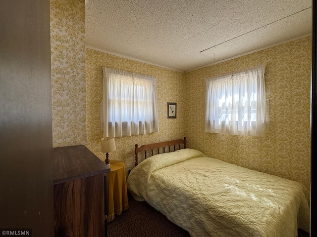 bedroom featuring ornamental molding, a textured ceiling, multiple windows, and wallpapered walls