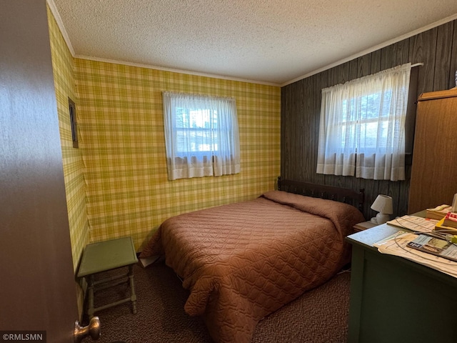 bedroom with crown molding, a textured ceiling, and multiple windows