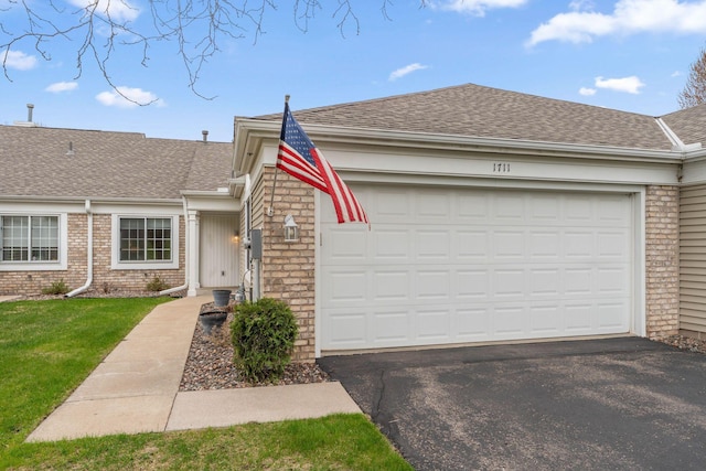 1711 121st Ln NW, Coon Rapids, MN 55448 - view of front of property with a shingled roof, asphalt driveway, and a garage