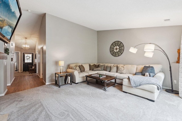 1711 121st Ln NW, Coon Rapids, MN 55448 - carpeted living room with a chandelier, baseboards, and vaulted ceiling