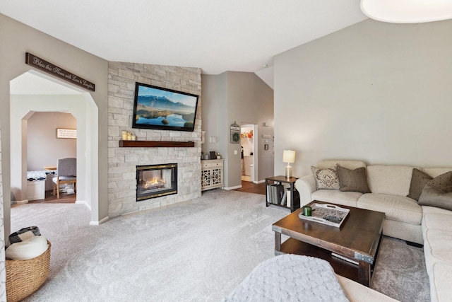1711 121st Ln NW, Coon Rapids, MN 55448 - carpeted living room with lofted ceiling, arched walkways, baseboards, and a stone fireplace