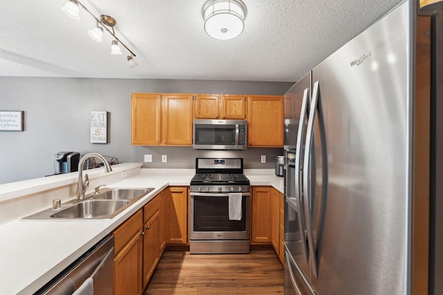 1711 121st Ln NW, Coon Rapids, MN 55448 - kitchen featuring stainless steel appliances, a sink, light countertops, wood finished floors, and a textured ceiling