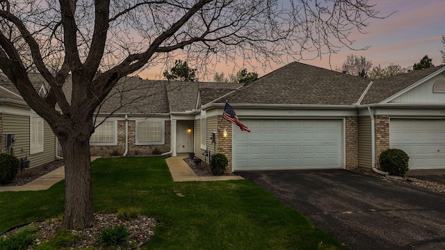 1711 121st Ln NW, Coon Rapids, MN 55448 - view of front facade with brick siding, a garage, driveway, a lawn, and roof with shingles