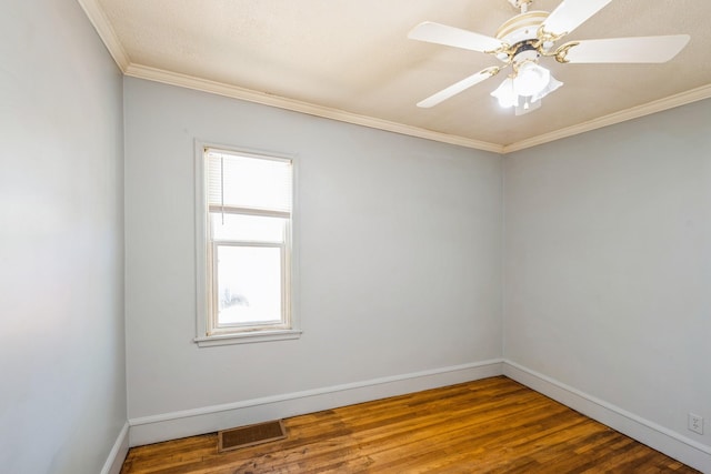 empty room featuring a ceiling fan, ornamental molding, baseboards, and wood finished floors