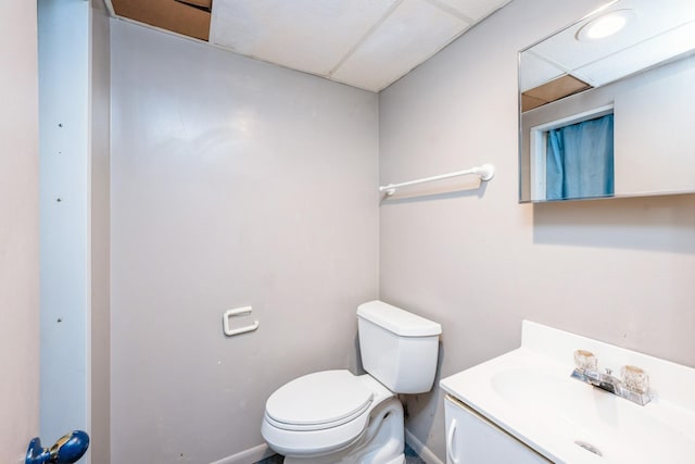 bathroom with toilet, vanity, and baseboards