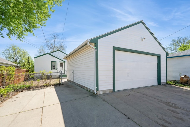 detached garage with fence and concrete driveway