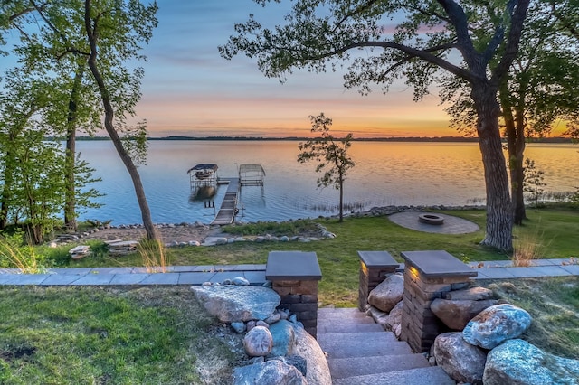 42429 Big Mcdonald Dr, Dent, MN 56528 - yard at dusk with a water view, a yard, a dock, and a fire pit