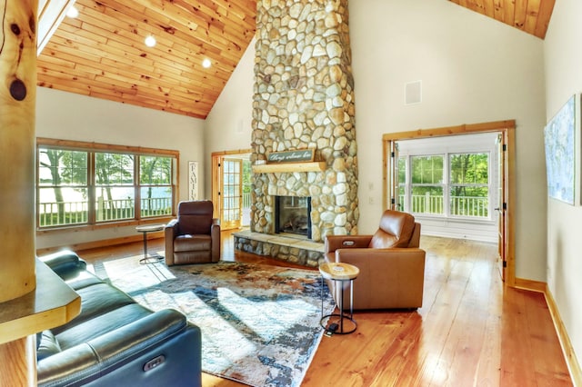 42429 Big Mcdonald Dr, Dent, MN 56528 - living area featuring high vaulted ceiling, hardwood / wood-style floors, a stone fireplace, wooden ceiling, and baseboards