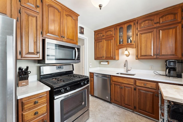 kitchen with a sink, light countertops, brown cabinetry, and stainless steel appliances