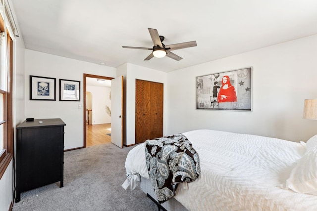 carpeted bedroom with a closet and a ceiling fan