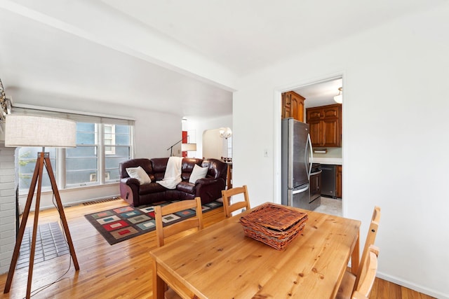 dining space featuring baseboards and light wood finished floors