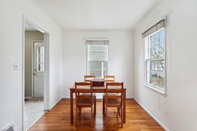 dining area with baseboards, light wood finished floors, and visible vents