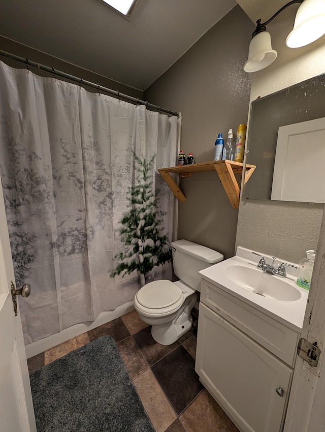 full bath featuring toilet, a textured wall, stone finish floor, and vanity