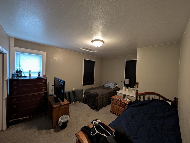 carpeted bedroom featuring a textured ceiling and visible vents