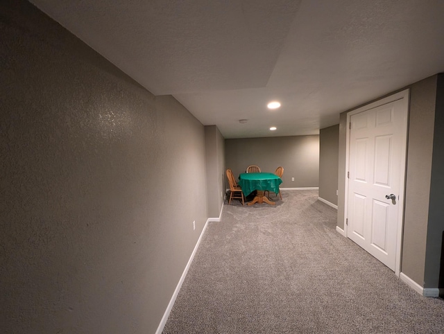 hallway with baseboards, recessed lighting, carpet, and a textured wall