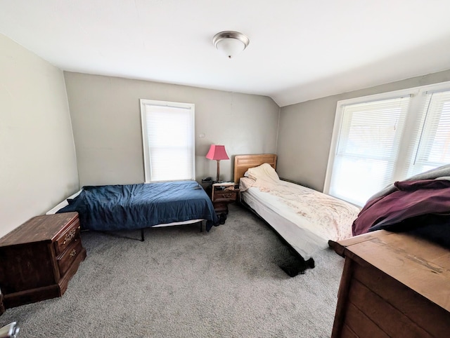 carpeted bedroom with lofted ceiling
