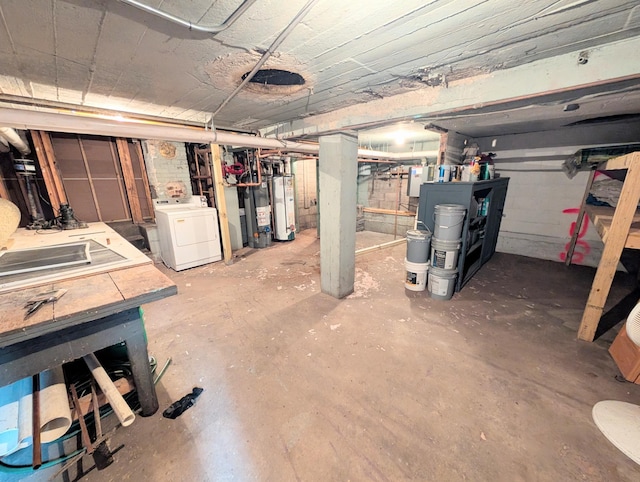 unfinished below grade area featuring washer / dryer and gas water heater