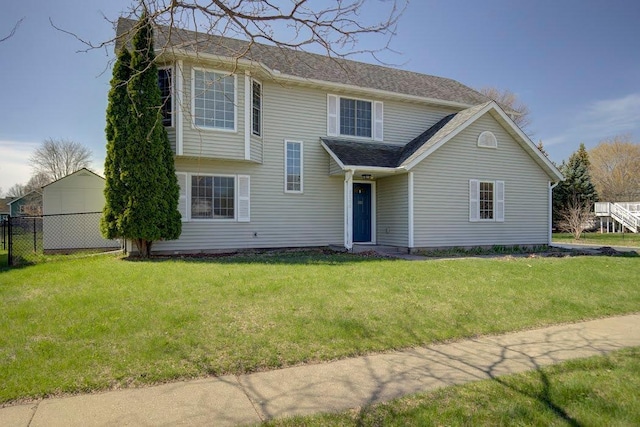 view of front of home with fence, a chimney, a shingled roof, and a front yard