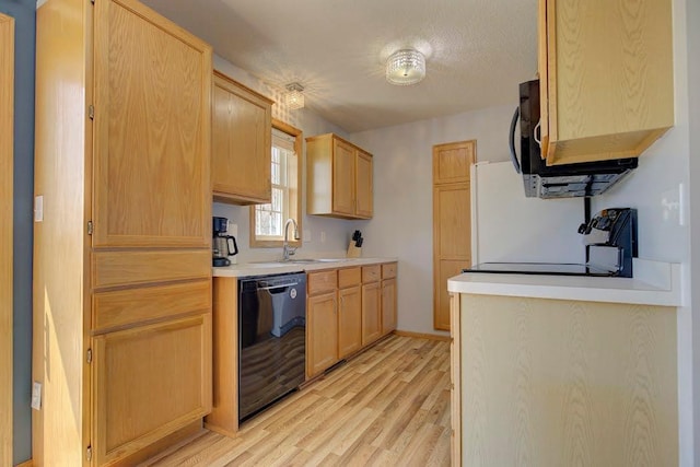 kitchen with a sink, light brown cabinets, light countertops, light wood-type flooring, and black appliances