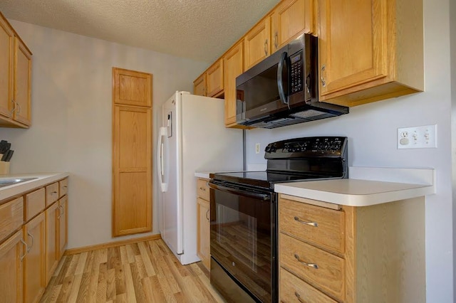 kitchen featuring light countertops, a textured ceiling, black range with electric stovetop, and light wood-style flooring