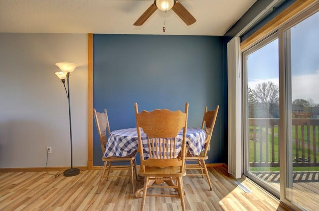 dining space featuring baseboards, ceiling fan, and wood finished floors