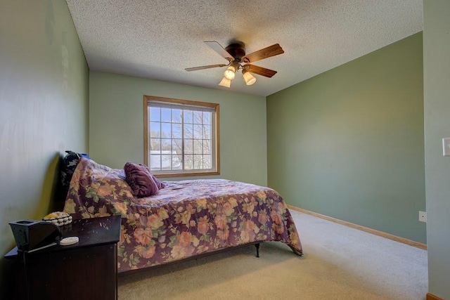 carpeted bedroom with a ceiling fan, a textured ceiling, and baseboards